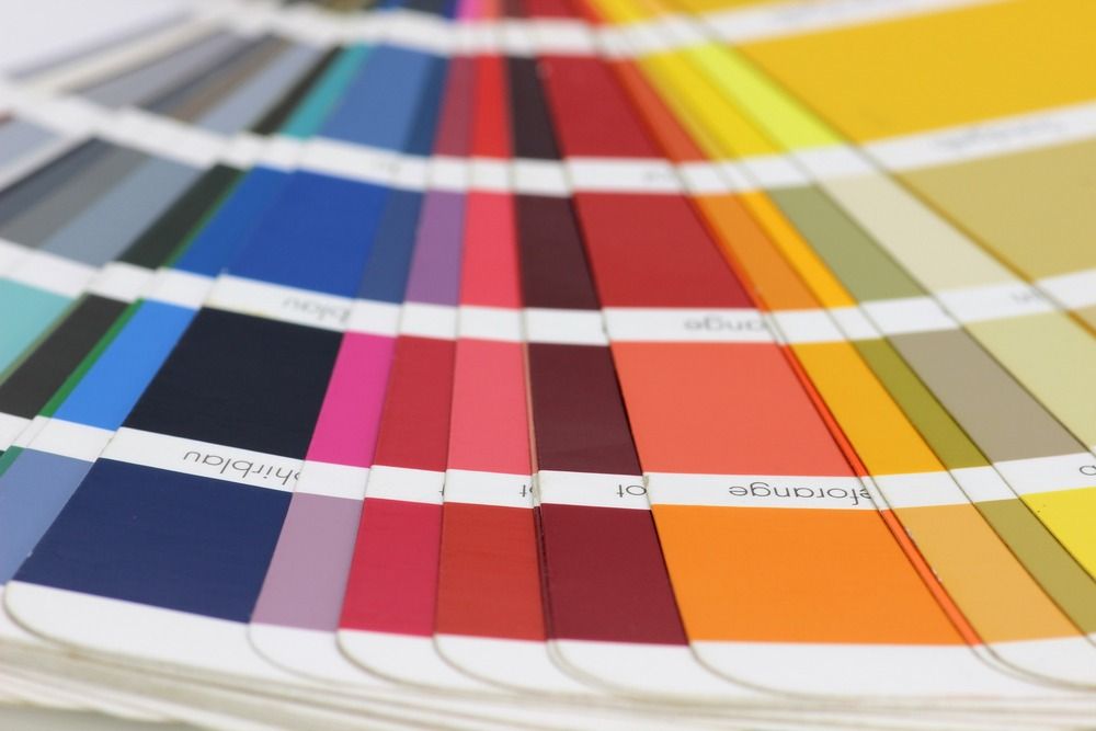 Abanico de muestras de color con vibrantes tonos azules, rosas, rojos, naranjas, amarillos y negros.